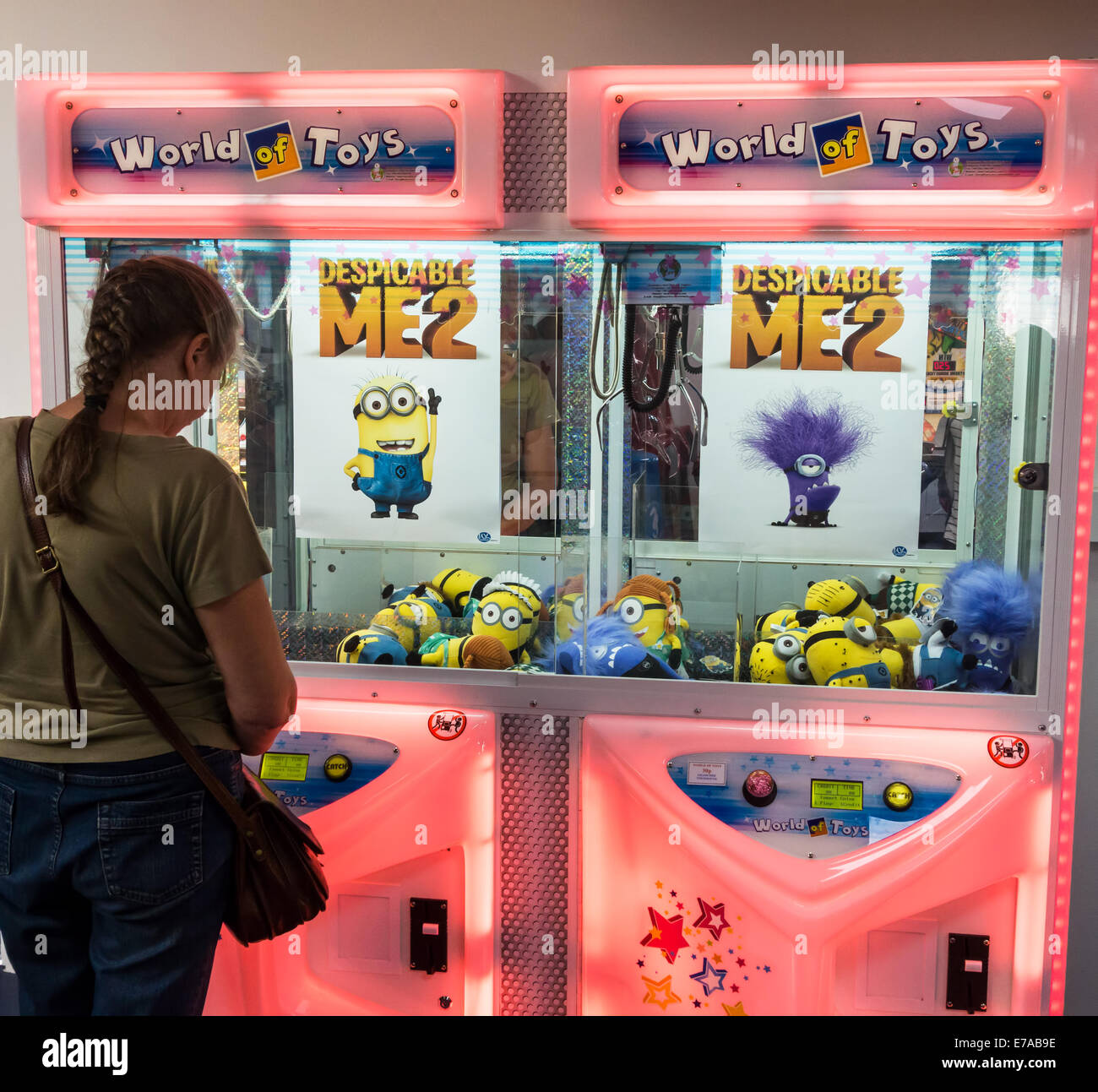 Une femme regarde une arcade toy machine sur la jetée de Teignmouth dans le Devon, Angleterre, Royaume-Uni. Banque D'Images