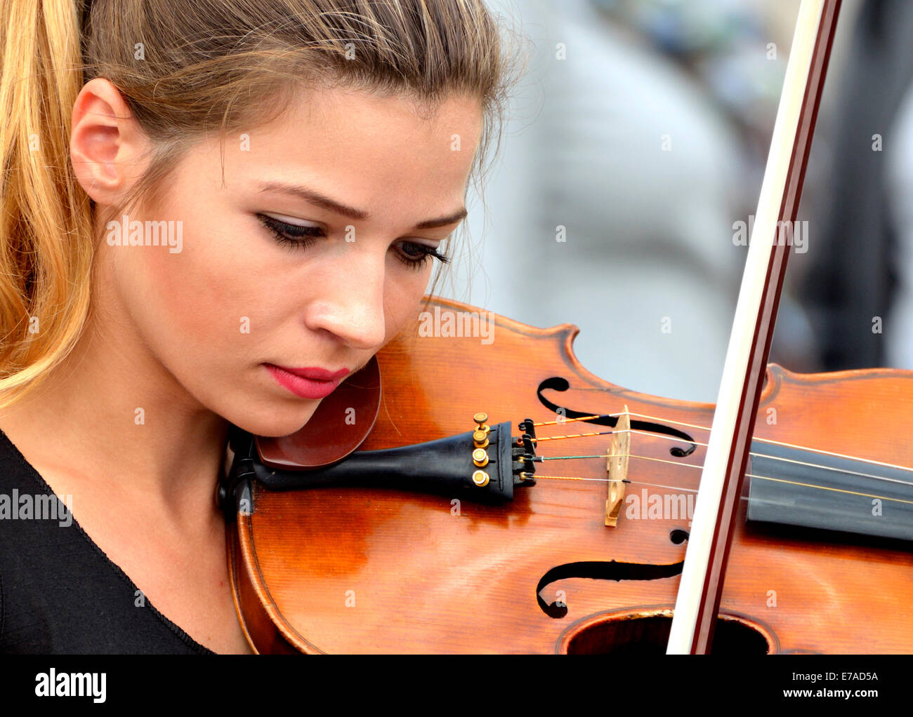 Londres, Angleterre, Royaume-Uni. Jeune femme de la rue sur le violon à Trafalgar Square Banque D'Images