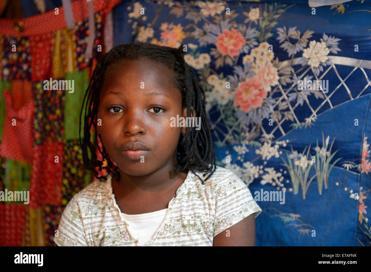 Girl, portrait, en face de chiffons colorés, Camp de réfugiés du séisme d'Icare, Fort National, Port-au-Prince, Haïti Banque D'Images