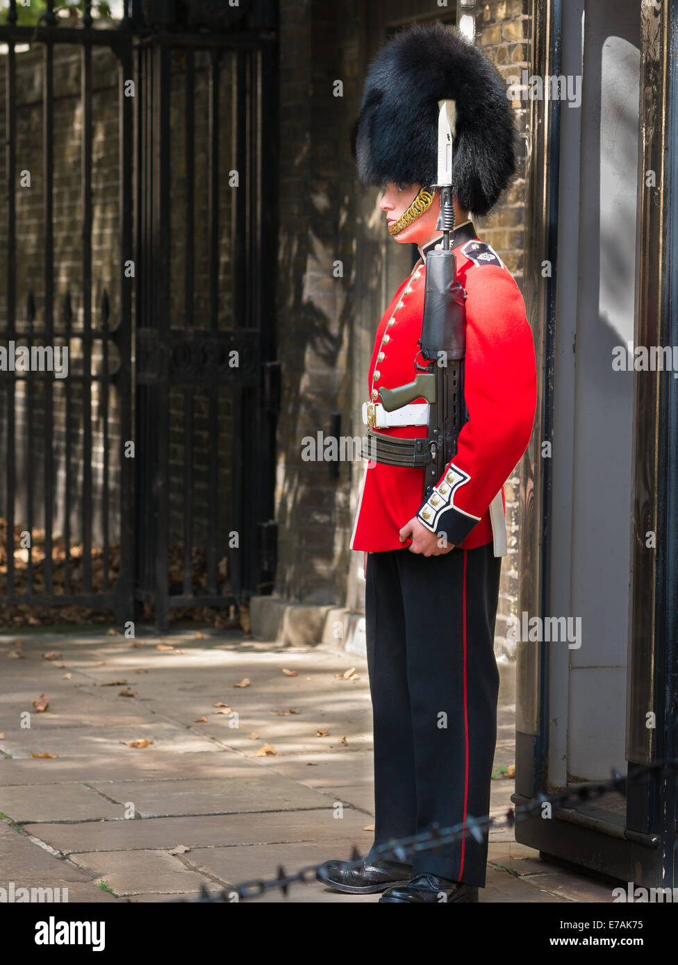 Soldat en manteau rouge et noir Busby sur la garde à l'extérieur Clarence  House, Londres Photo Stock - Alamy