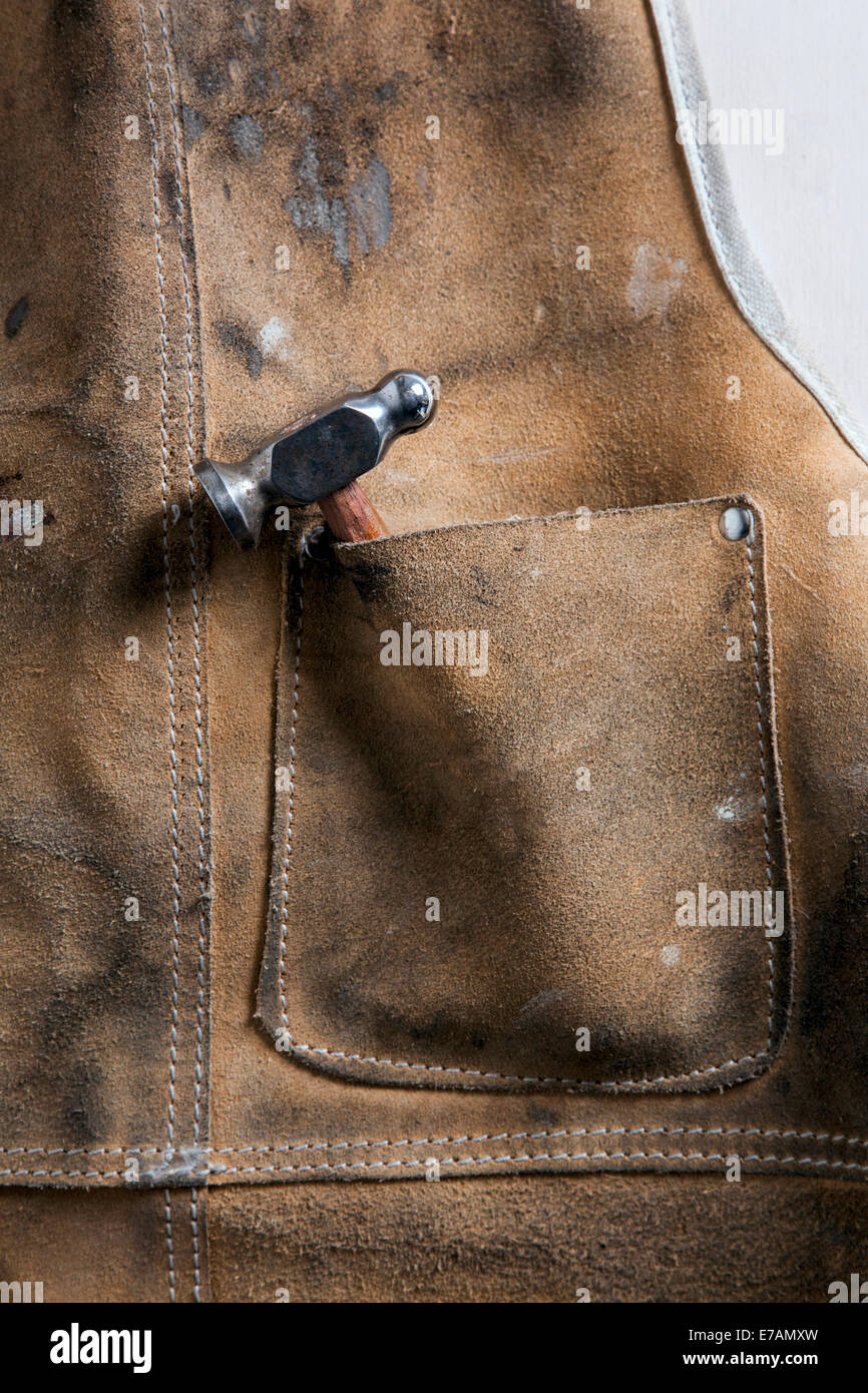 Atelier cuir tablier avec un marteau chassant dans la poche. Banque D'Images