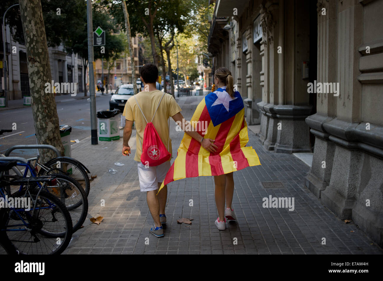 Barcelone, Espagne. Sep 11, 2014. Un couple portant un drapeau catalan indépendantiste promenades dans les rues de Barcelone. Une grande manifestation en faveur de l'indépendance a eu lieu dans les rues de Barcelone pendant la fête nationale catalane exigeant la célébration d'un referundum d'une sécession de l'Espagne le 9 novembre prochain. Crédit : Jordi Boixareu/Alamy Live News Banque D'Images