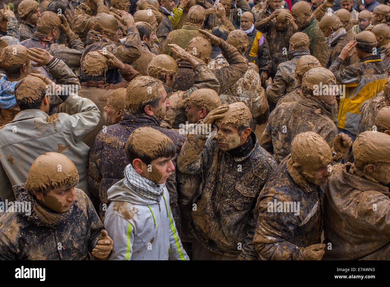 Hommes et garçons musulmans chiites, couvert de boue, le chant et l'auto-flagellating pendant Ashoura, dans Bijar, Iran. Banque D'Images