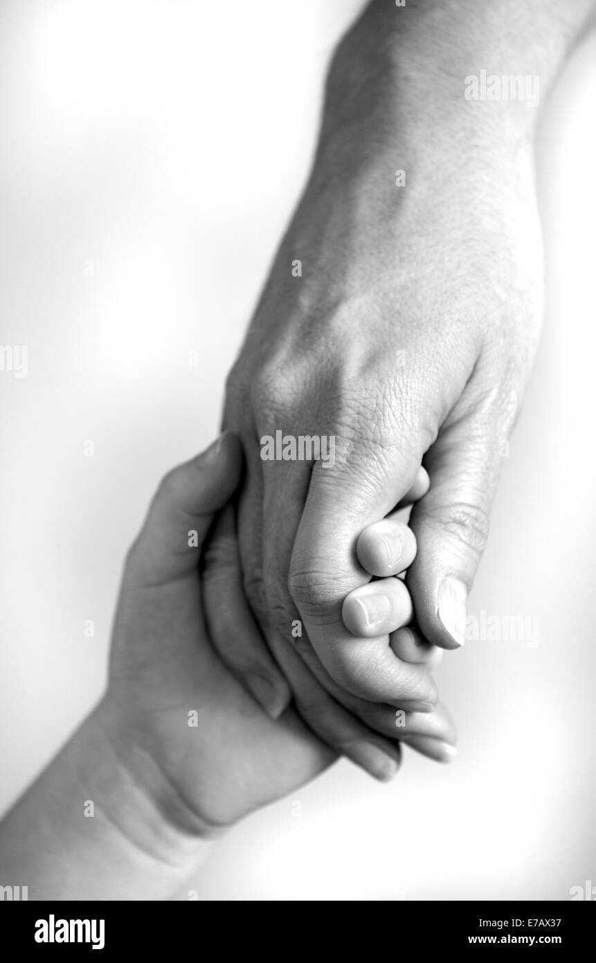 Adulte ou un parent qui tient la main d'un petit enfant Banque D'Images