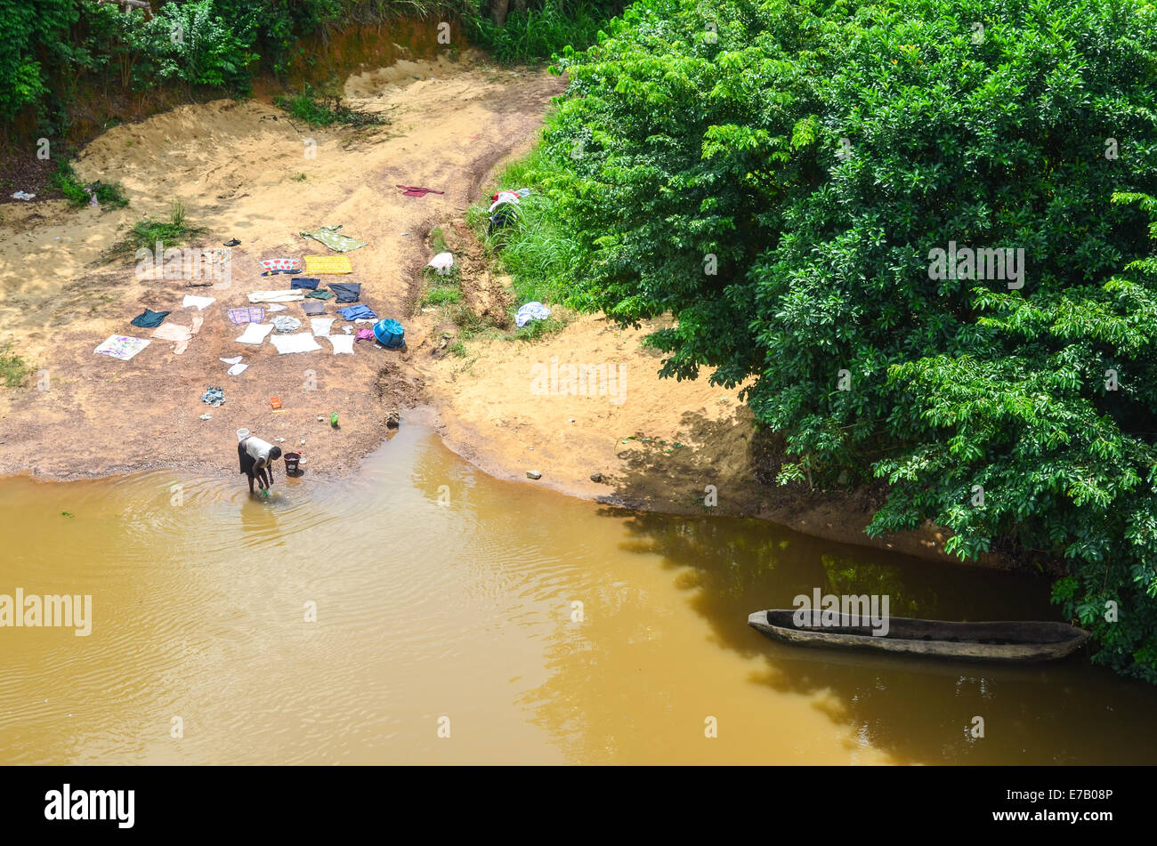 Girl dans une rivière de l'eau marron en Sierra Leone Banque D'Images