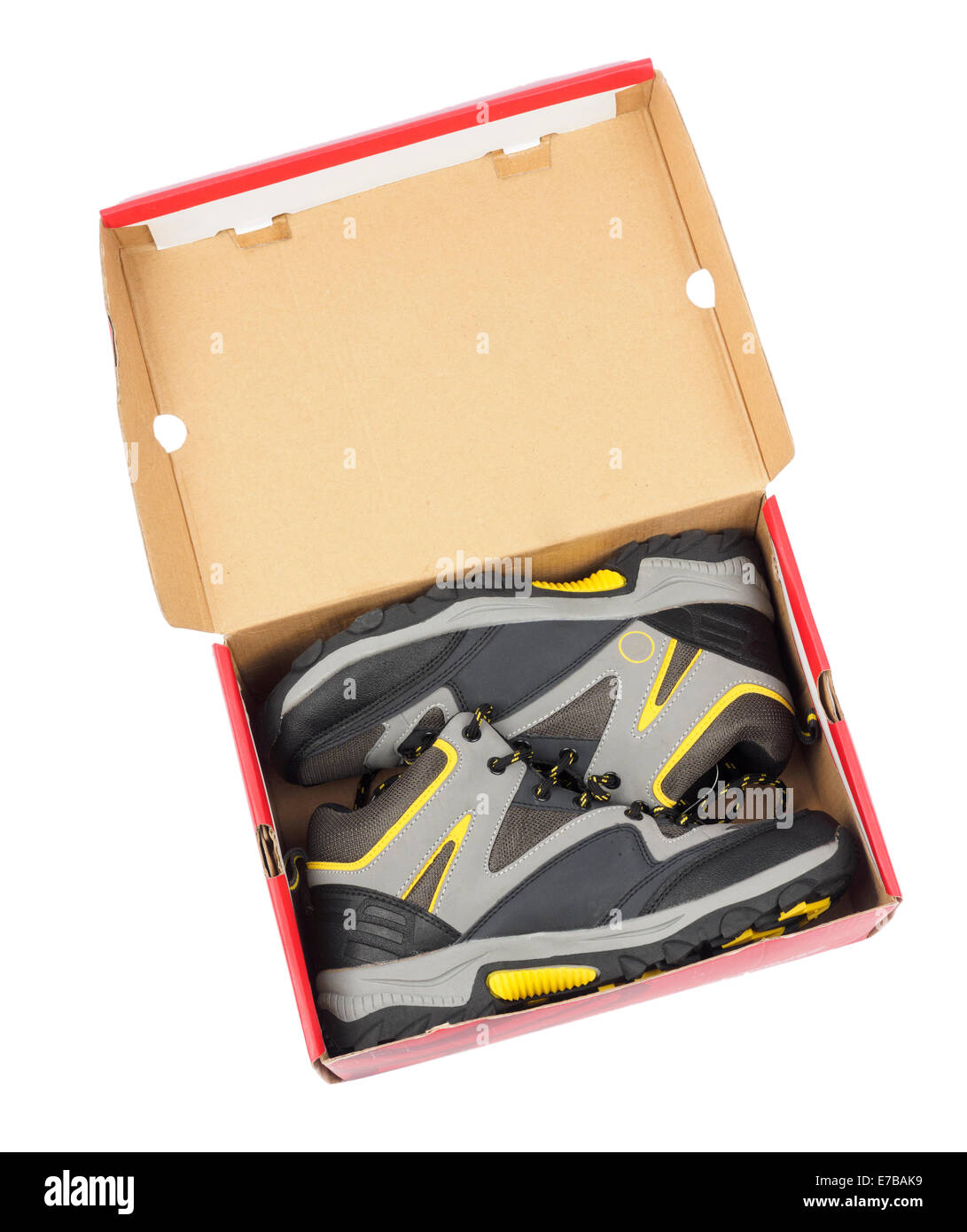 Une paire de chaussures de randonnée gris et jaune sur une case rouge isolé sur fond blanc Banque D'Images
