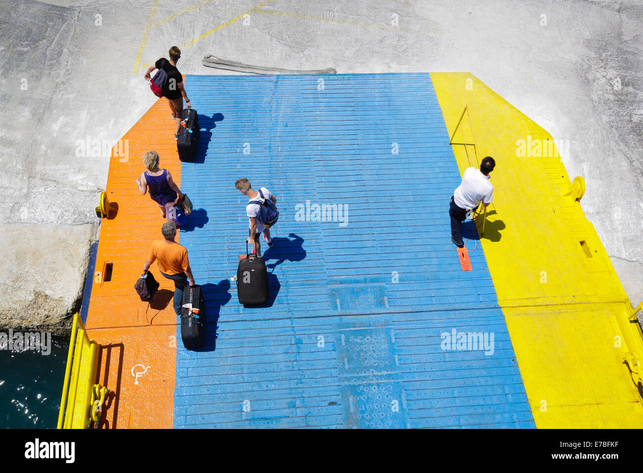 Les passagers débarquant d'un Greek islands ferry le long de sa passerelle colorés Banque D'Images