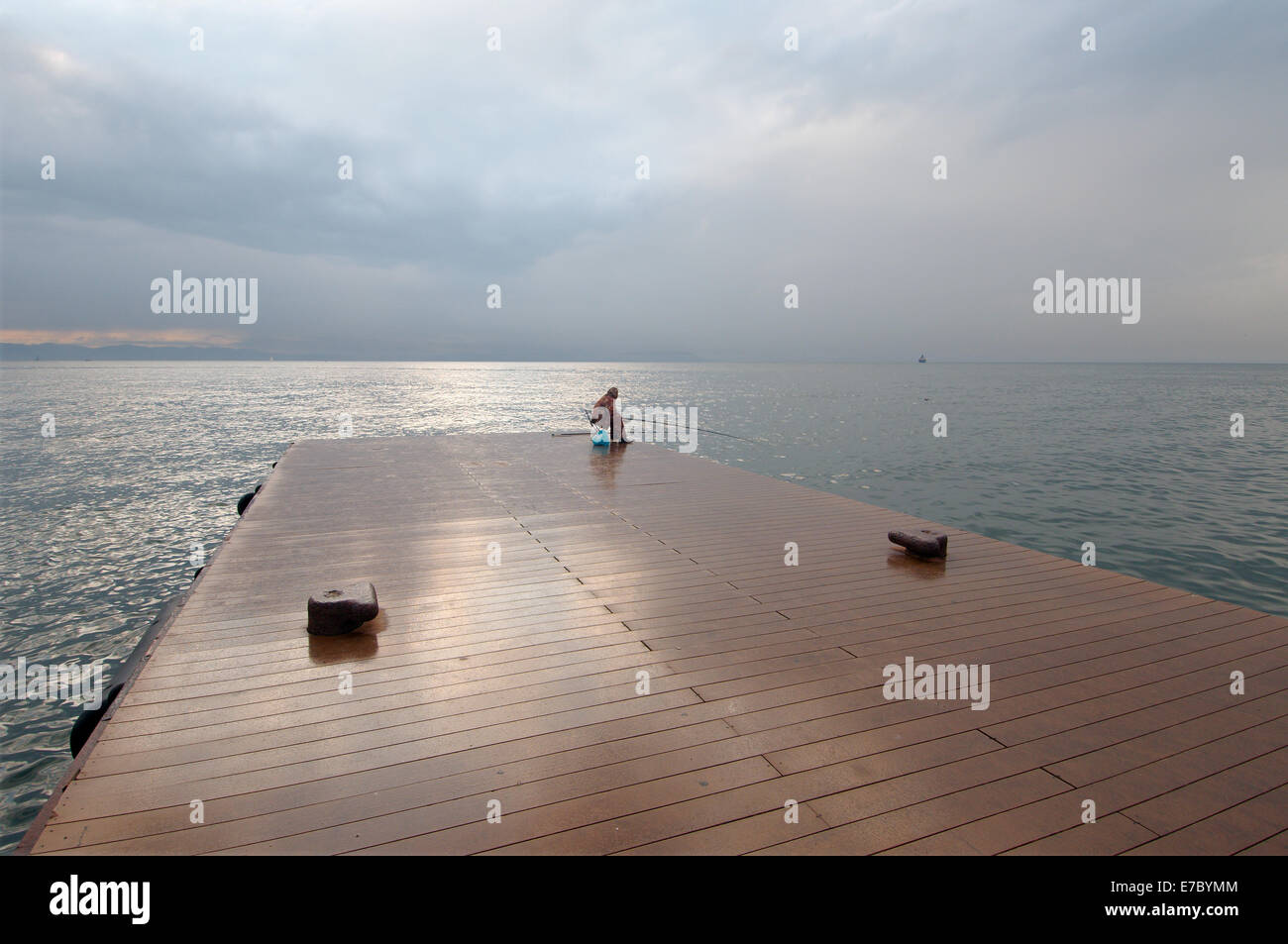 Pêcheur assis sur la jetée et la pêche dans la mer du Japon, Vladivostok, en Extrême-Orient, Primorye territory, Russie Banque D'Images