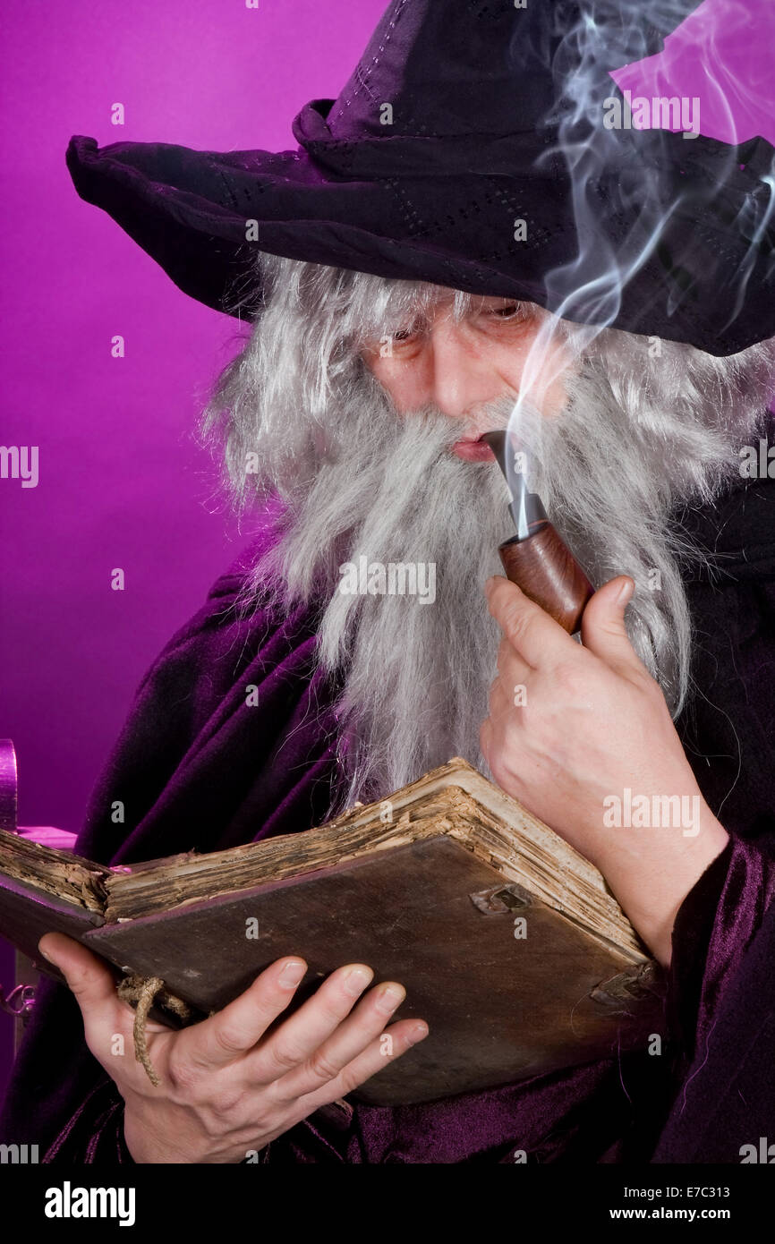 Vieux Sorcier Lire Un Livre Et Fumant Une Pipe Photo Stock Alamy