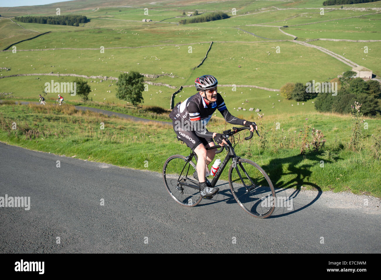 Randonnées cycliste une forte pente dans le Yorkshire Dales National Park Banque D'Images