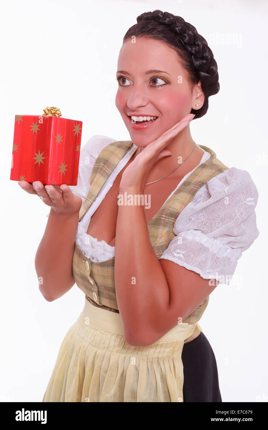 Belle femme en dirndl avec cadeau de Noël dans la main Banque D'Images