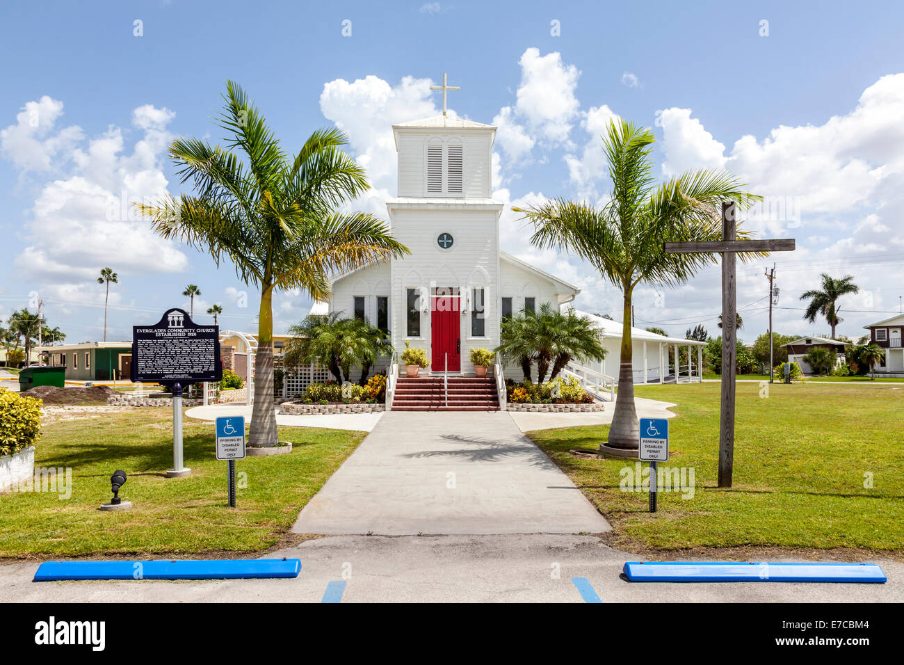 Trottoir, porte d'entrée avant rouge et clocher de l'église communautaire sur Broadway Avenue West à Everglades City, Floride, USA. Banque D'Images