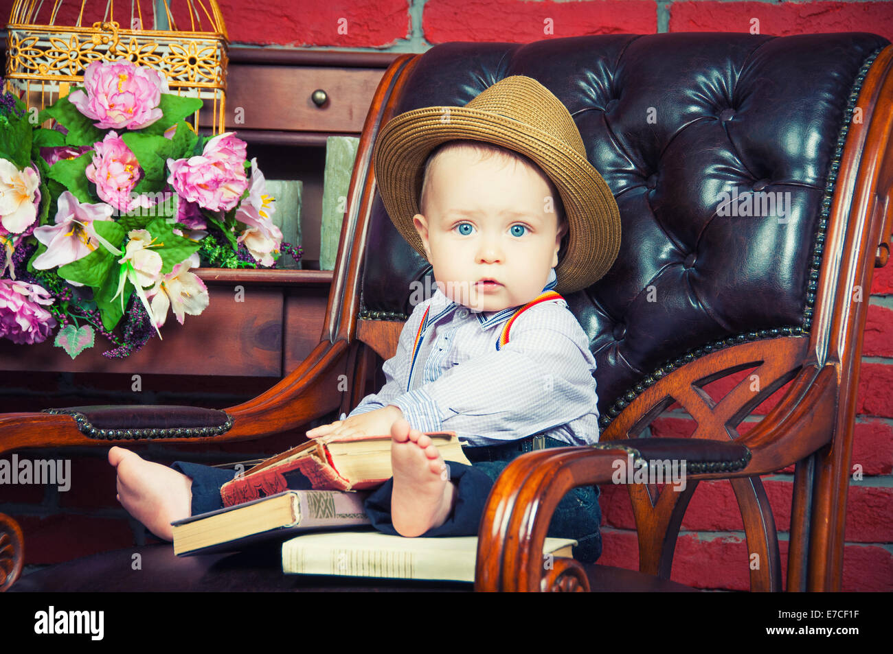 Petit Patron Bebe Assis Dans Un Fauteuil En Cuir Dans Le Chapeau Photo Stock Alamy
