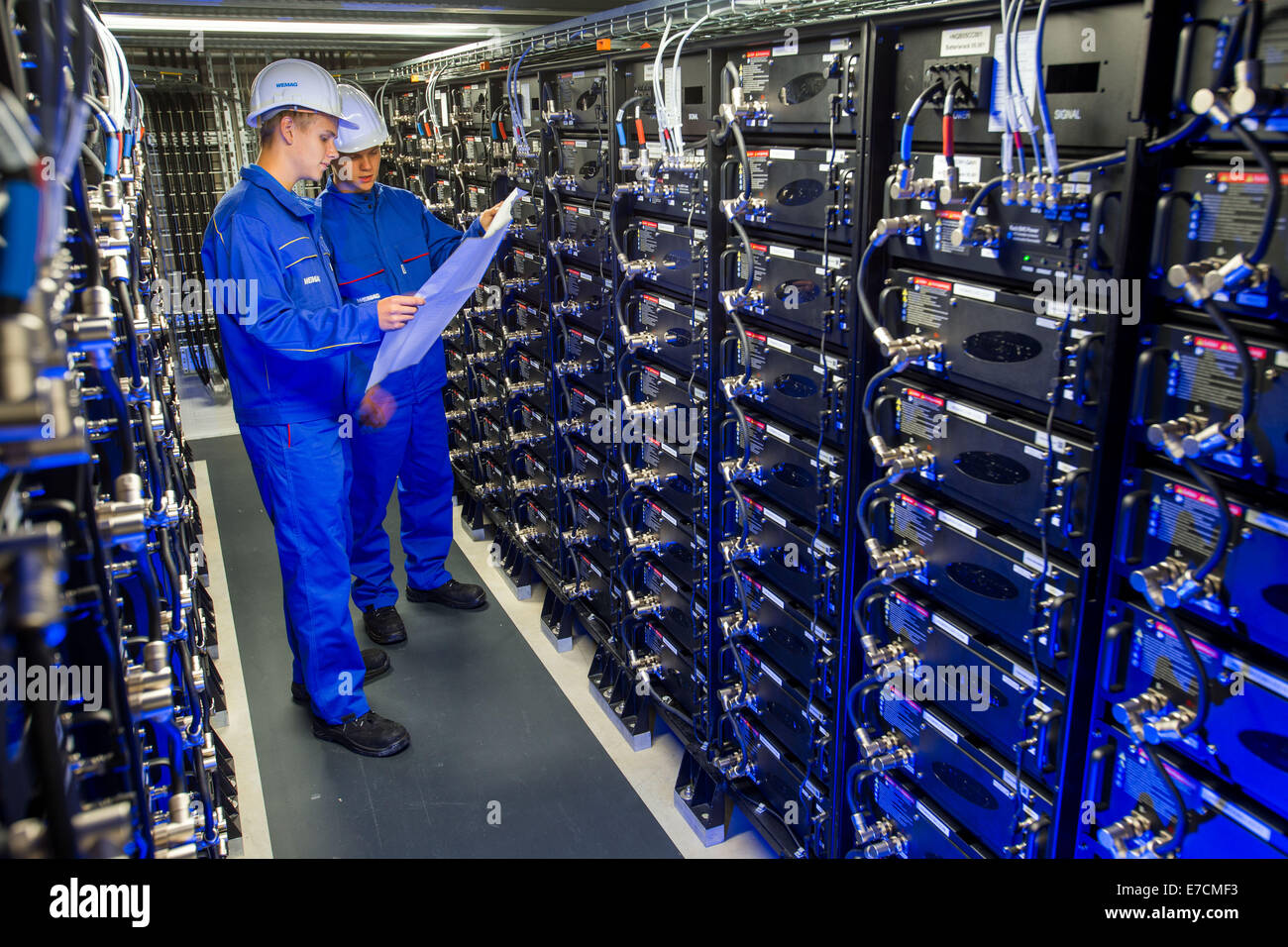 Schwerin, Allemagne. Sep 10, 2014. Stagiaires Philipp Bathke et Alexander Klatt vérifiez les connexions d'alimentation d'une rangée de stockage la plus grande batterie commerciale facitily en Europe à Schwerin, Allemagne, 10 septembre 2014. Les cinq mégawatts a été construit par la compagnie d'électricité allemande WEMAG et sera solennellement mis en ligne le 16 septembre 2014. Il vous aidera à stabiliser le réseau électrique. Photo : JENS BUETTNER/dpa/Alamy Live News Banque D'Images