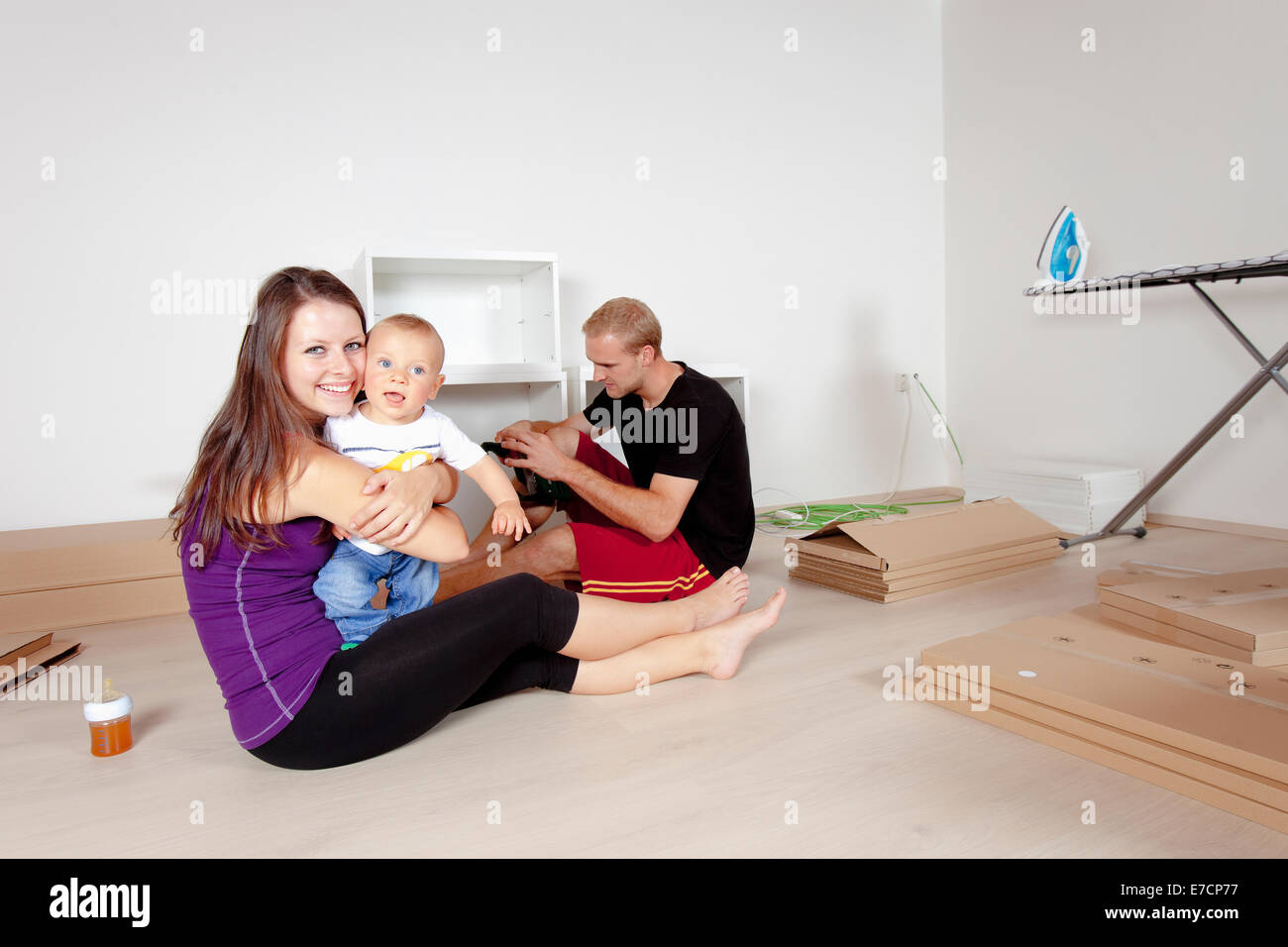 Jeune famille avec un bébé déménagement dans un nouvel appartement Banque D'Images