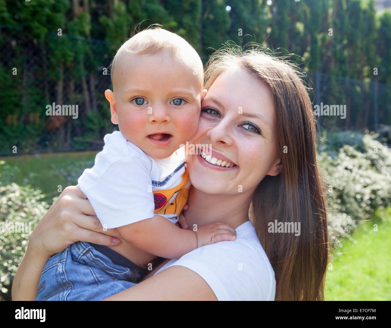 Jeune mère avec son bébé dans le jardin Smiling Banque D'Images