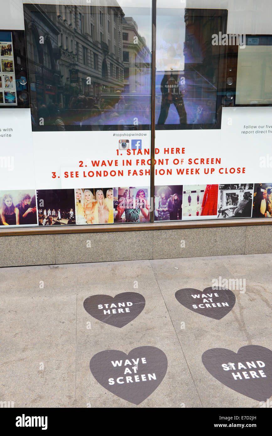 Oxford Circus, Londres, Royaume-Uni. 14 septembre 2014. Fashion show en direct sur grand écran dans la fenêtre de l'flagship sur Oxford Street, cinq utilisateurs Instagram partagent leur propre point de vue de la nouvelle collection que l'émission est diffusée. Crédit : Matthieu Chattle/Alamy Live News Banque D'Images