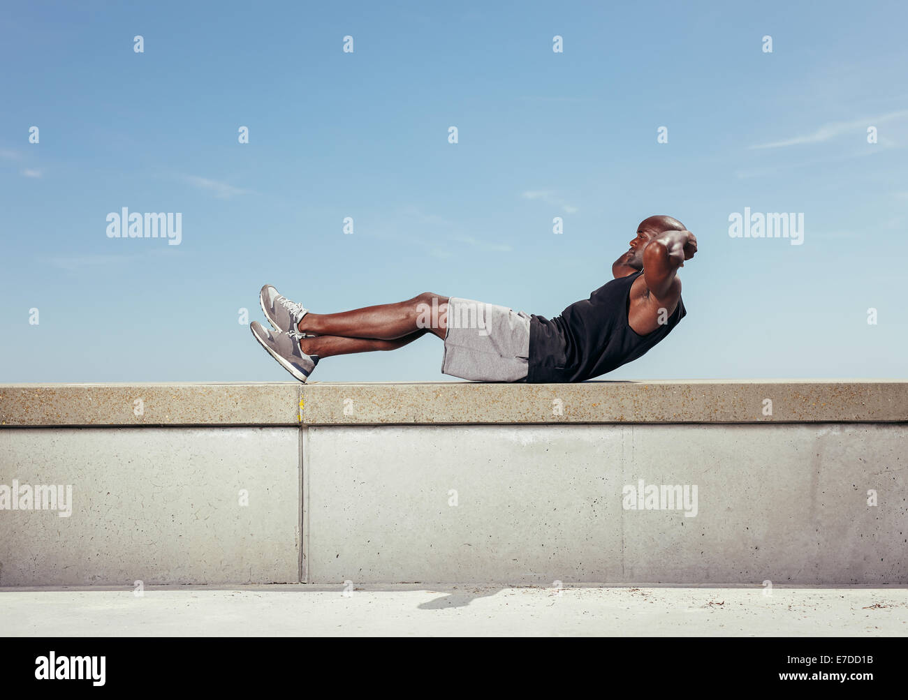Athlète faisant reposer-se lève contre le ciel. Modèle masculin de l'Afrique de l'exercice en plein air avec copie espace. Banque D'Images