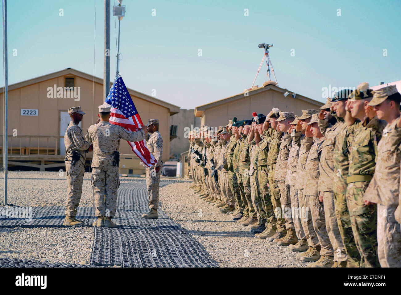 Les forces de la coalition dans le Commandement régional sud-ouest de saluer comme les États-Unis l'indicateur est soulevée au cours de la cérémonie de commémoration du 11 septembre 11 septembre 2014 au Camp Sapadalure, province de Helmand, en Afghanistan. Banque D'Images