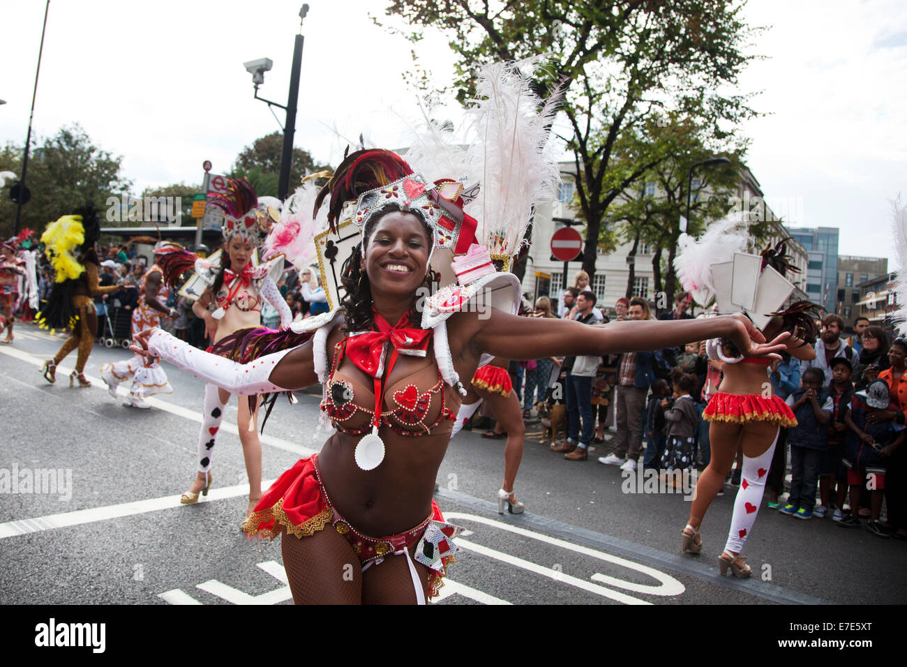 Danseuses vêtues de rouge et blanc plumes et costumes carte faire montrer leurs coups en face de l'hôtel de ville de Hackney Banque D'Images