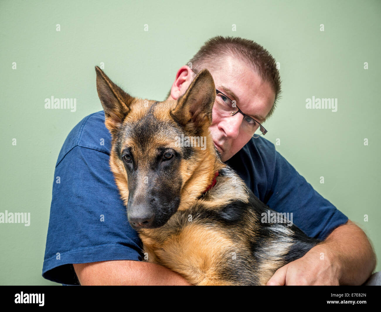 Heureux Jeune homme posant avec son animal berger allemand Banque D'Images