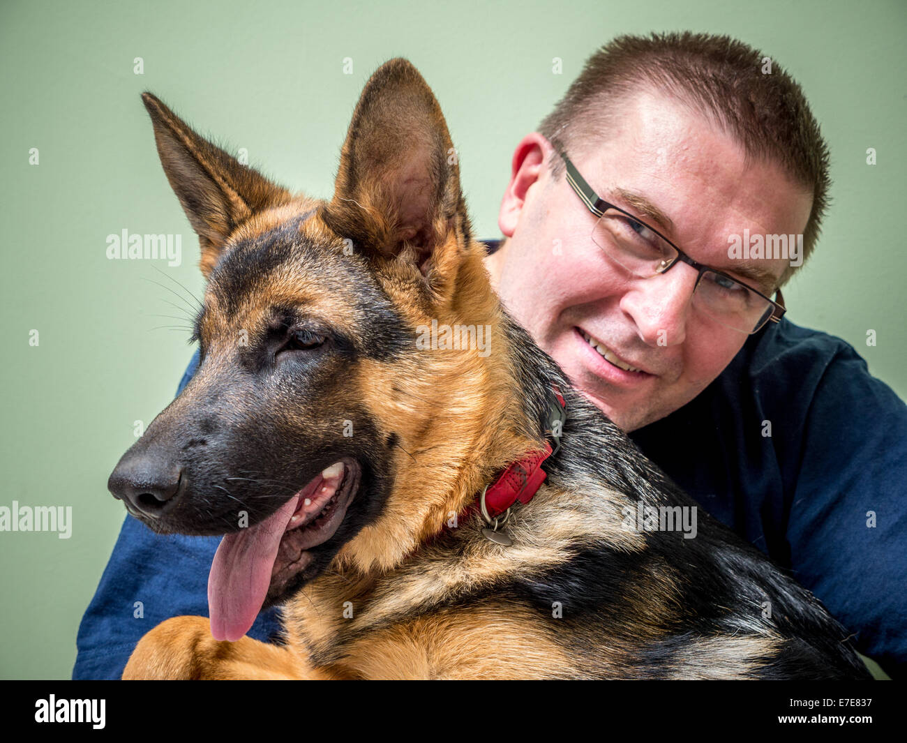 Heureux Jeune homme posant avec son animal berger allemand Banque D'Images