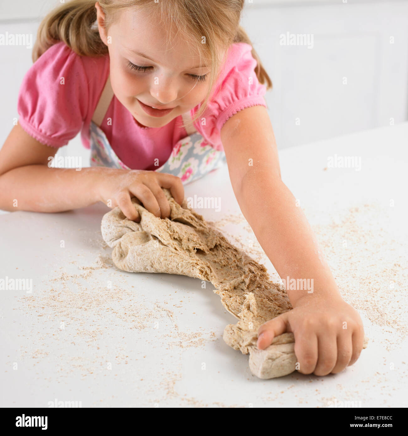 Fille de déchirer la pâte de pain, 5 ans Banque D'Images