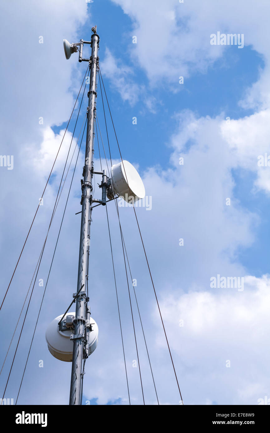 La tour de radio de communication avec les appareils au-dessus de fond de ciel bleu Banque D'Images