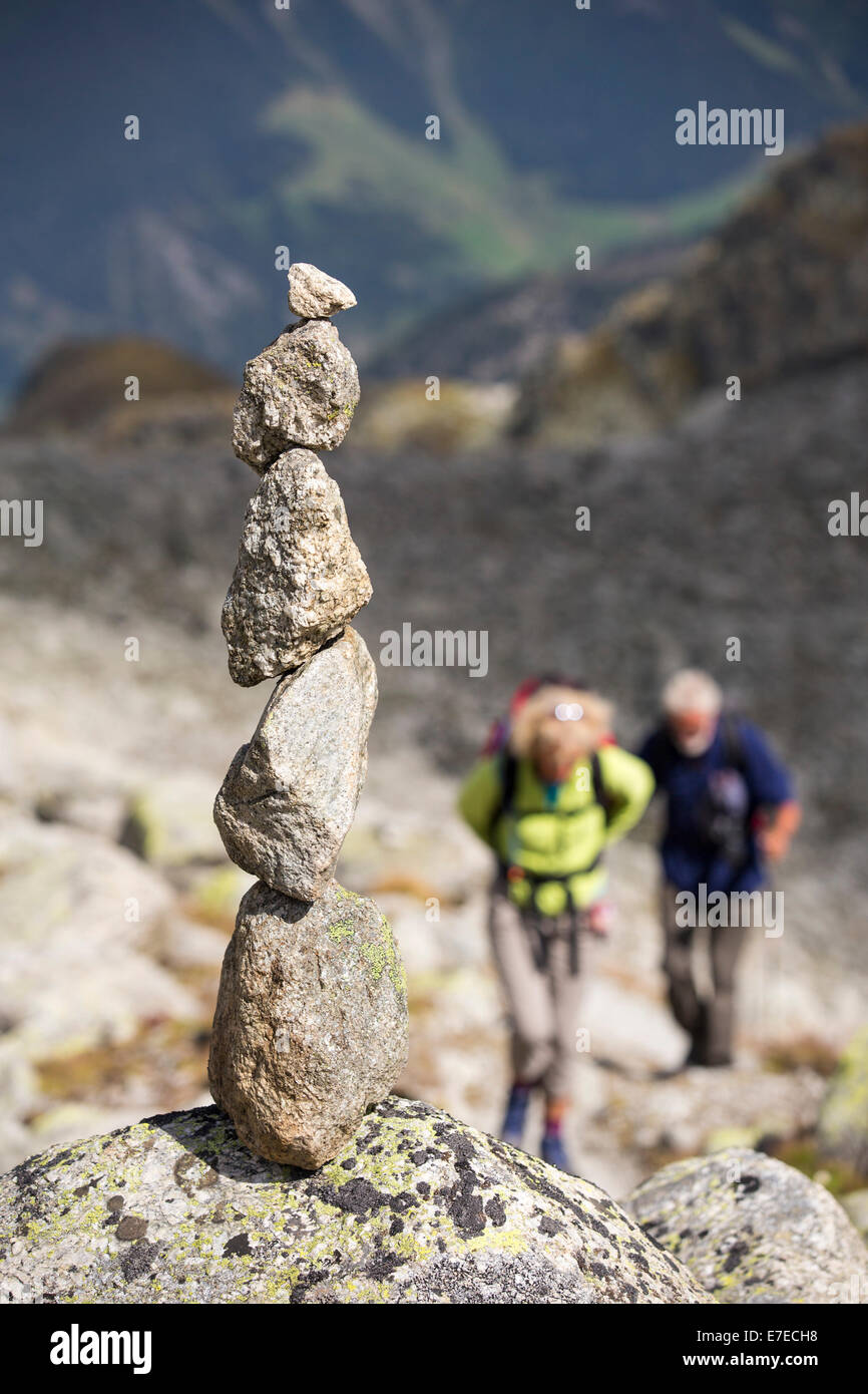 Les marcheurs faisant le tour du Mont blanc ascension vers la Cabanne d'Orny au-dessus de Val Ferret dans les Alpes suisses, avec une pierre blanced Banque D'Images