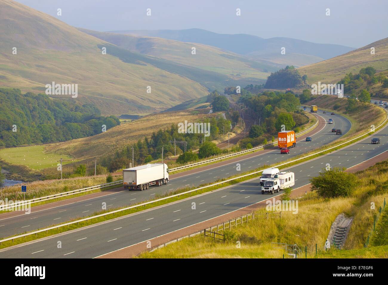 Camions sur l'autoroute M6 dans la vallée de la rivière Lune. Howgills, Cumbria, West Coast Main Line, England, UK. Banque D'Images