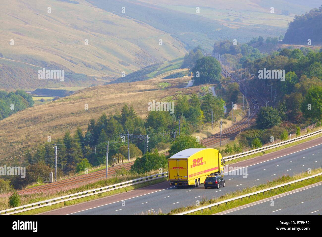 DHL Express camion sur l'autoroute M6 dans la vallée de la rivière Lune. Howgills, Cumbria, West Coast Main Line, England, UK. Banque D'Images