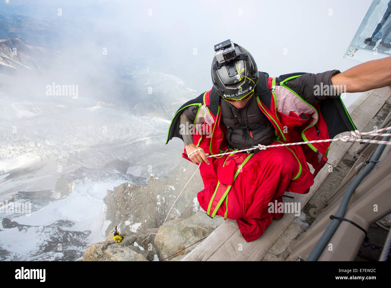 Les cavaliers de base portant des suites de l'aile se préparent à aller de  l'Aiguille du midi au-dessus de Chamonix, en France, avec les touristes  dans une cage de verre l'abîme à