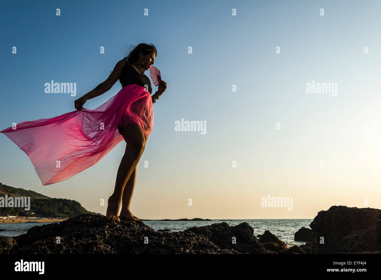Jeune femme indienne portant une jupe rose, posant sur la plage,, Inde Banque D'Images