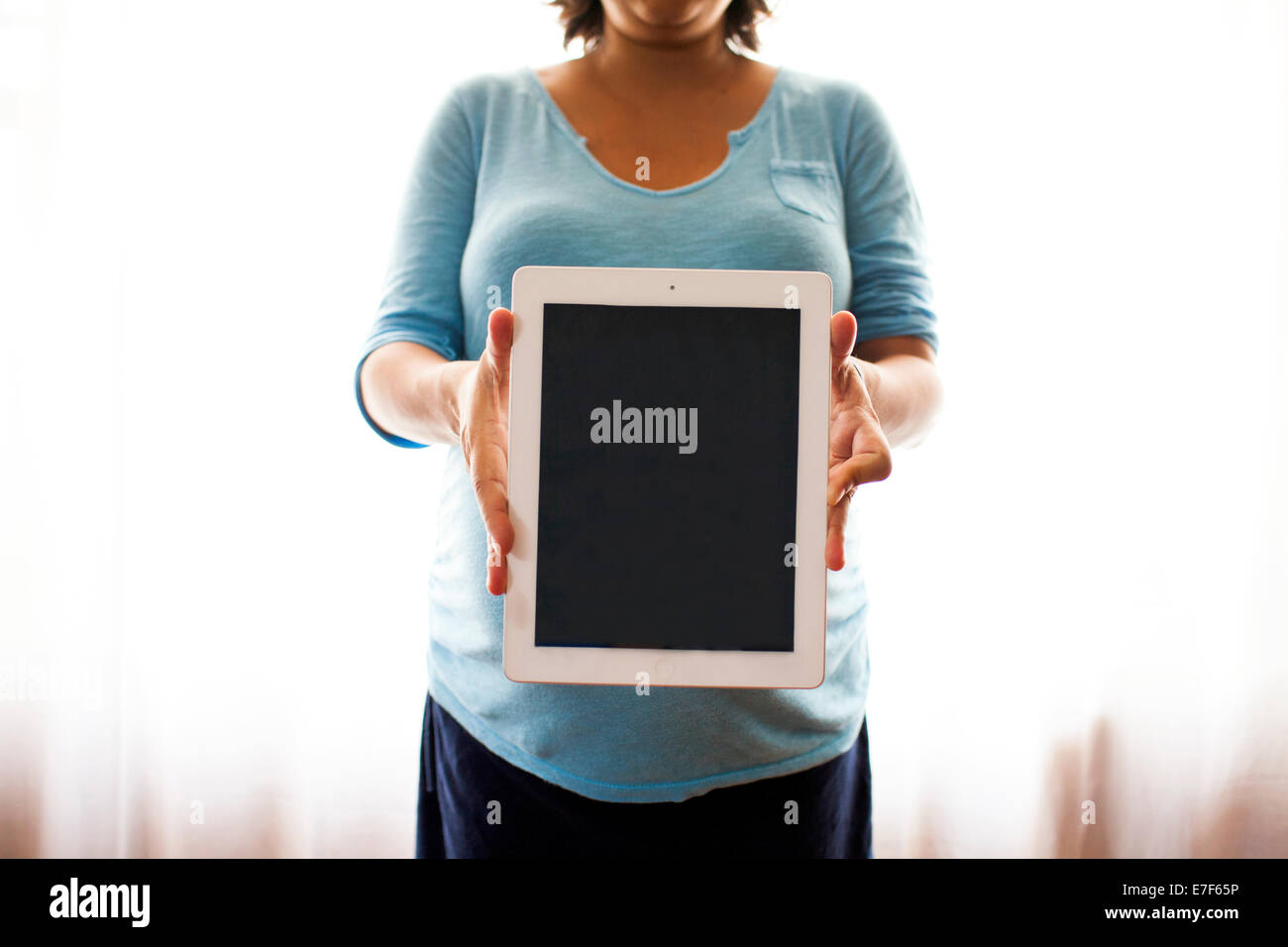 Pregnant Hispanic woman holding tablet computer Banque D'Images