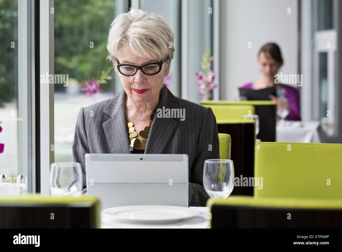 Caucasian businesswoman using tablet computer in restaurant Banque D'Images