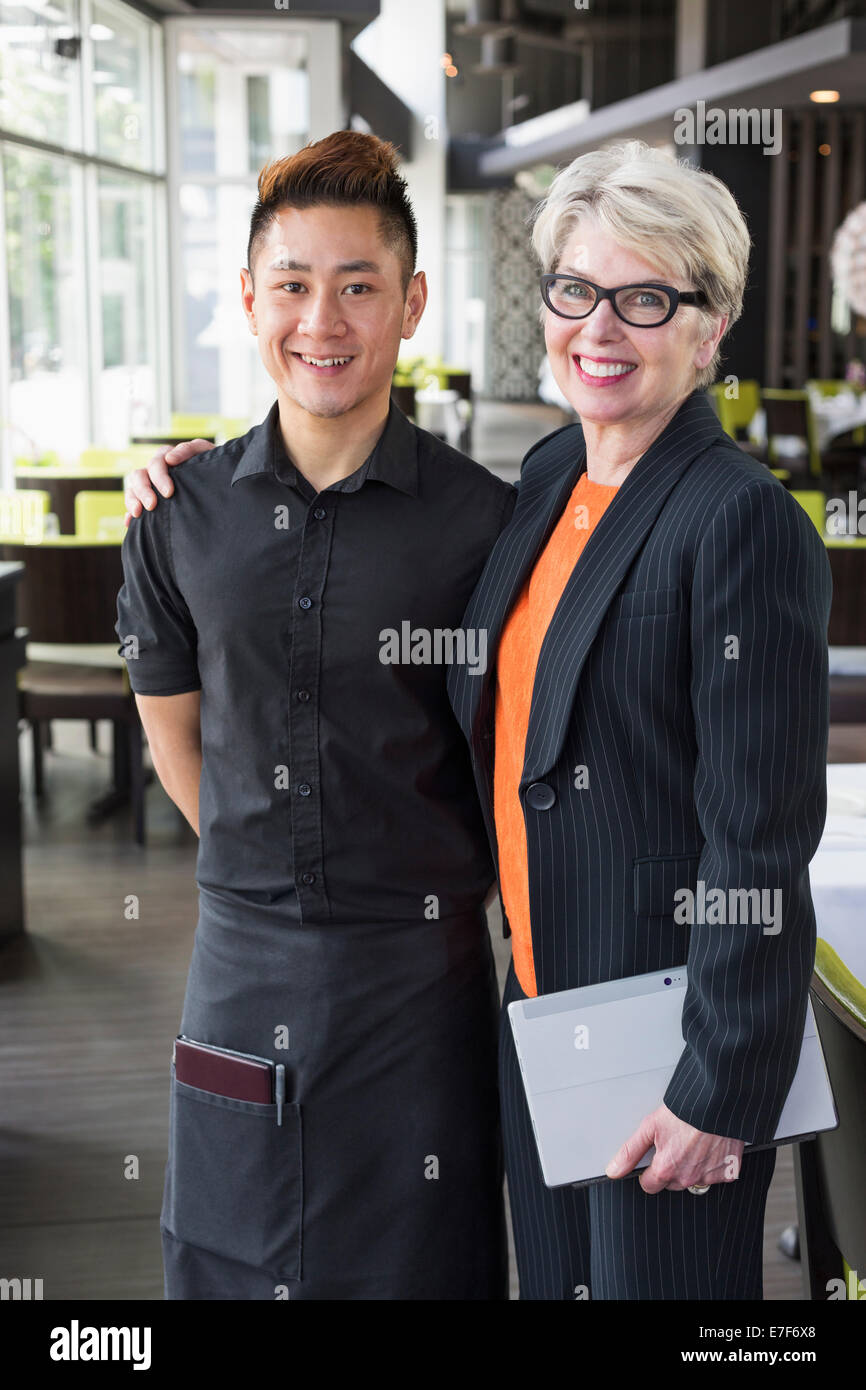 Businesswoman smiling in restaurant et de l'eau Banque D'Images Businesswoman smiling in restaurant et de l'eau Banque D'Images