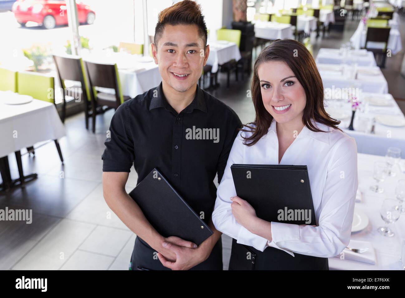 Serveur et serveuse smiling together in restaurant Banque D'Images Serveur et serveuse smiling together in restaurant Banque D'Images