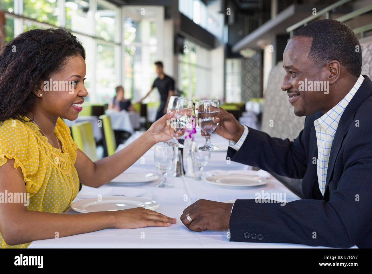 African American couple toasting each other in restaurant Banque D'Images