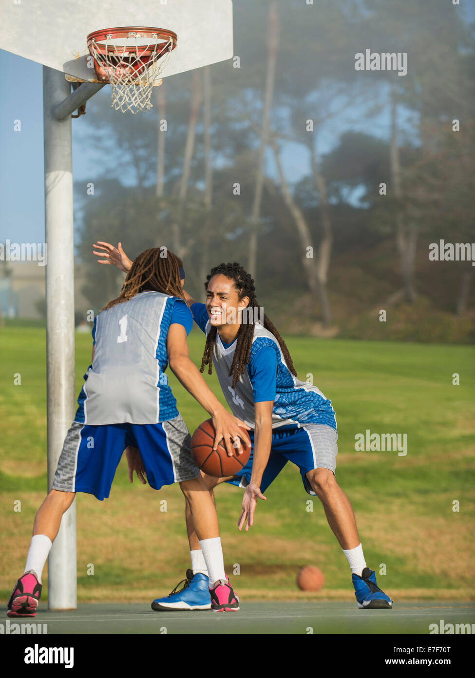 Les adolescents noirs jouant au basket-ball sur cour Banque D'Images