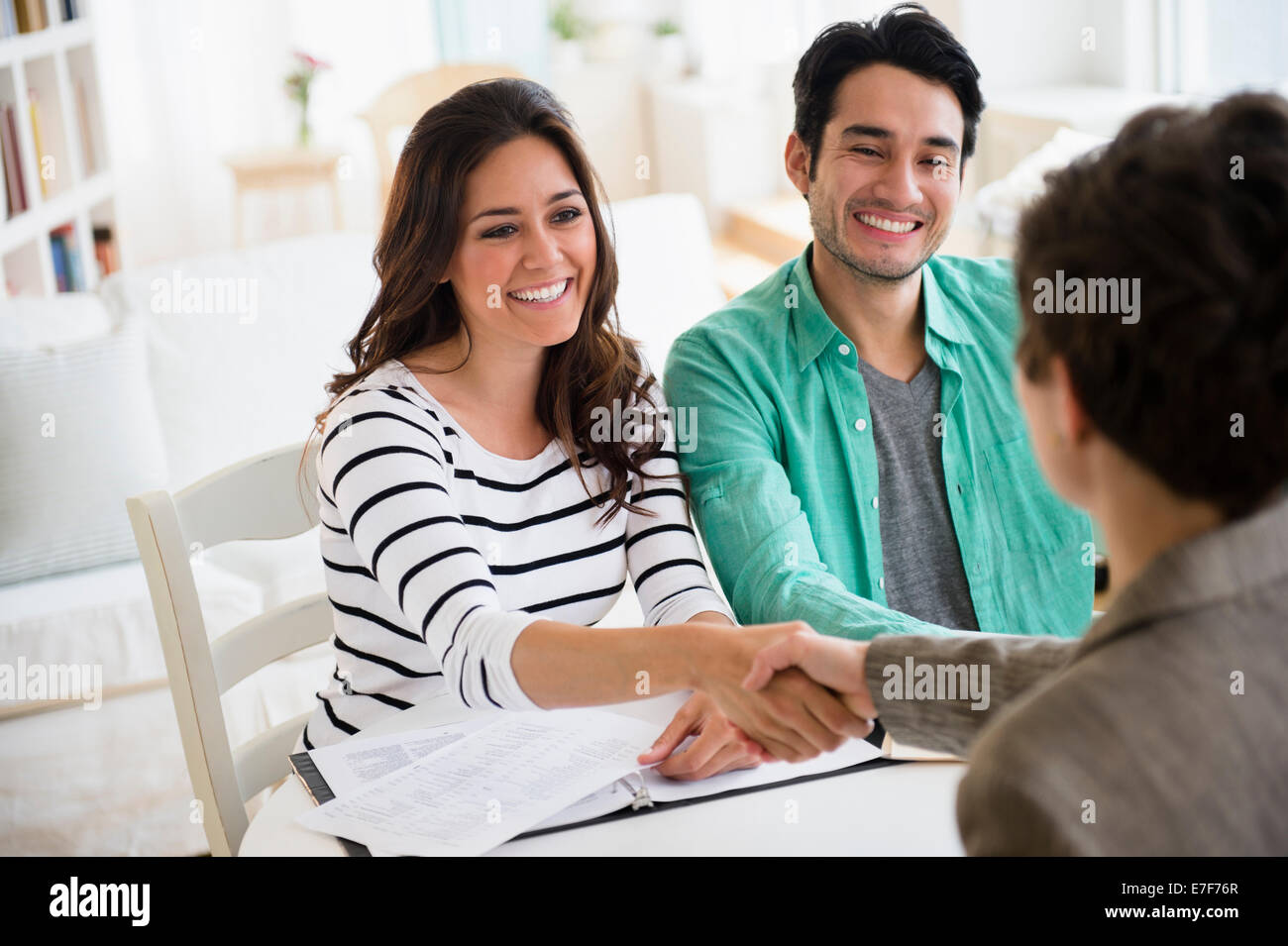 Couple shaking hands with financial adviser Banque D'Images