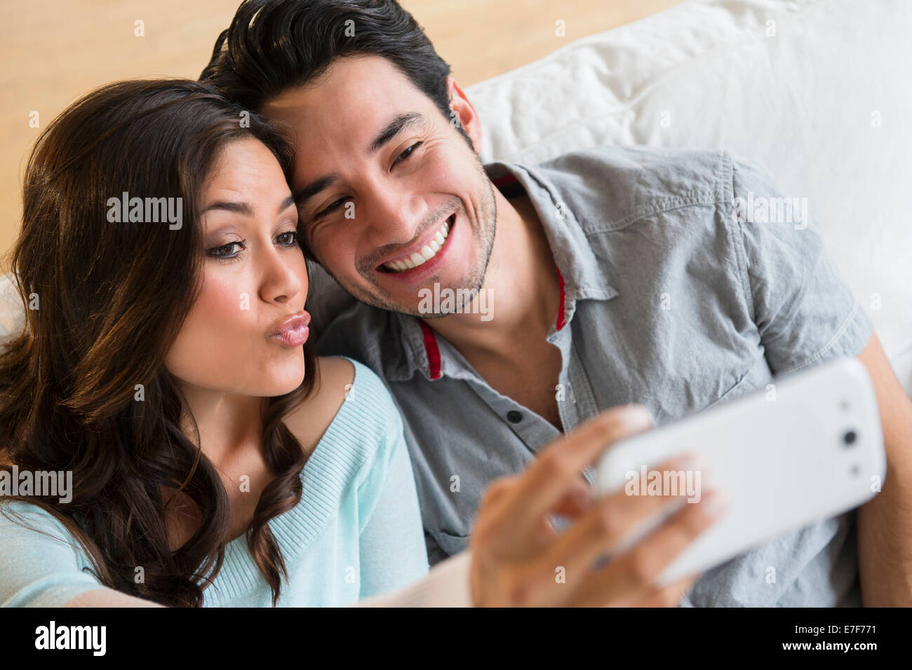 Couple taking pictures ensemble sur canapé Banque D'Images
