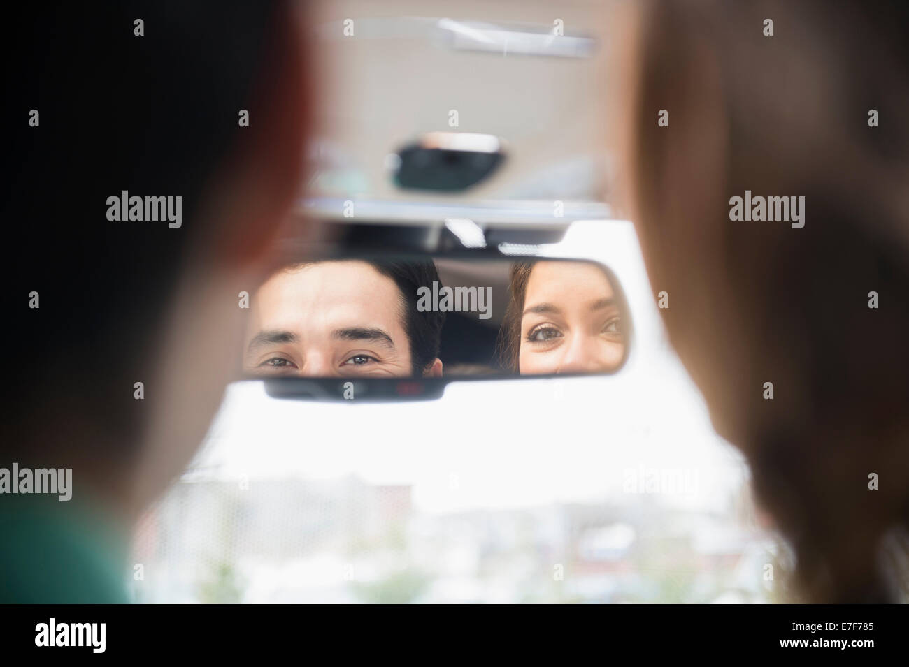 Couple admiring eux-mêmes dans rétroviseur Banque D'Images
