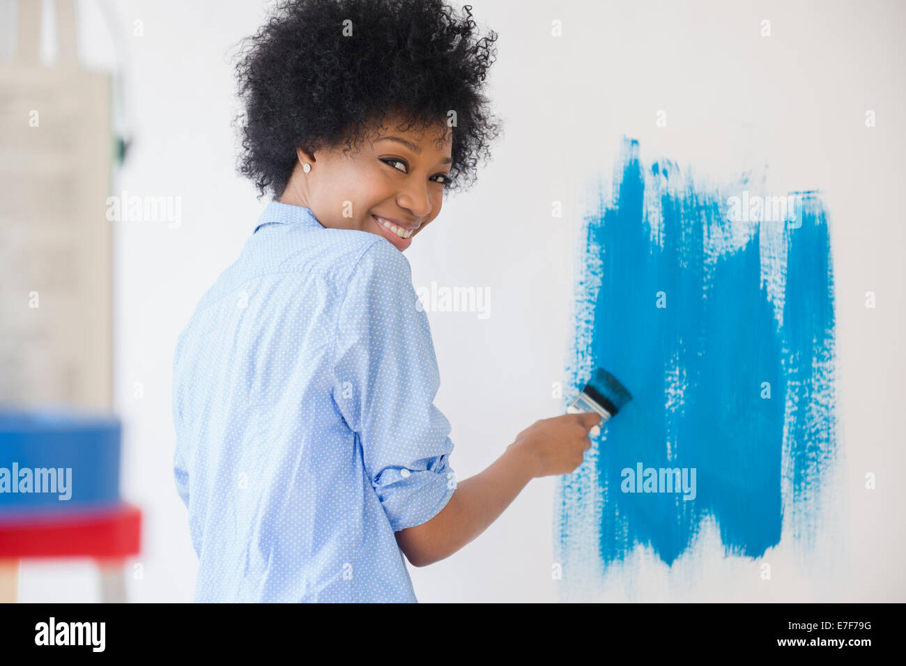 African American Woman painting wall Banque D'Images