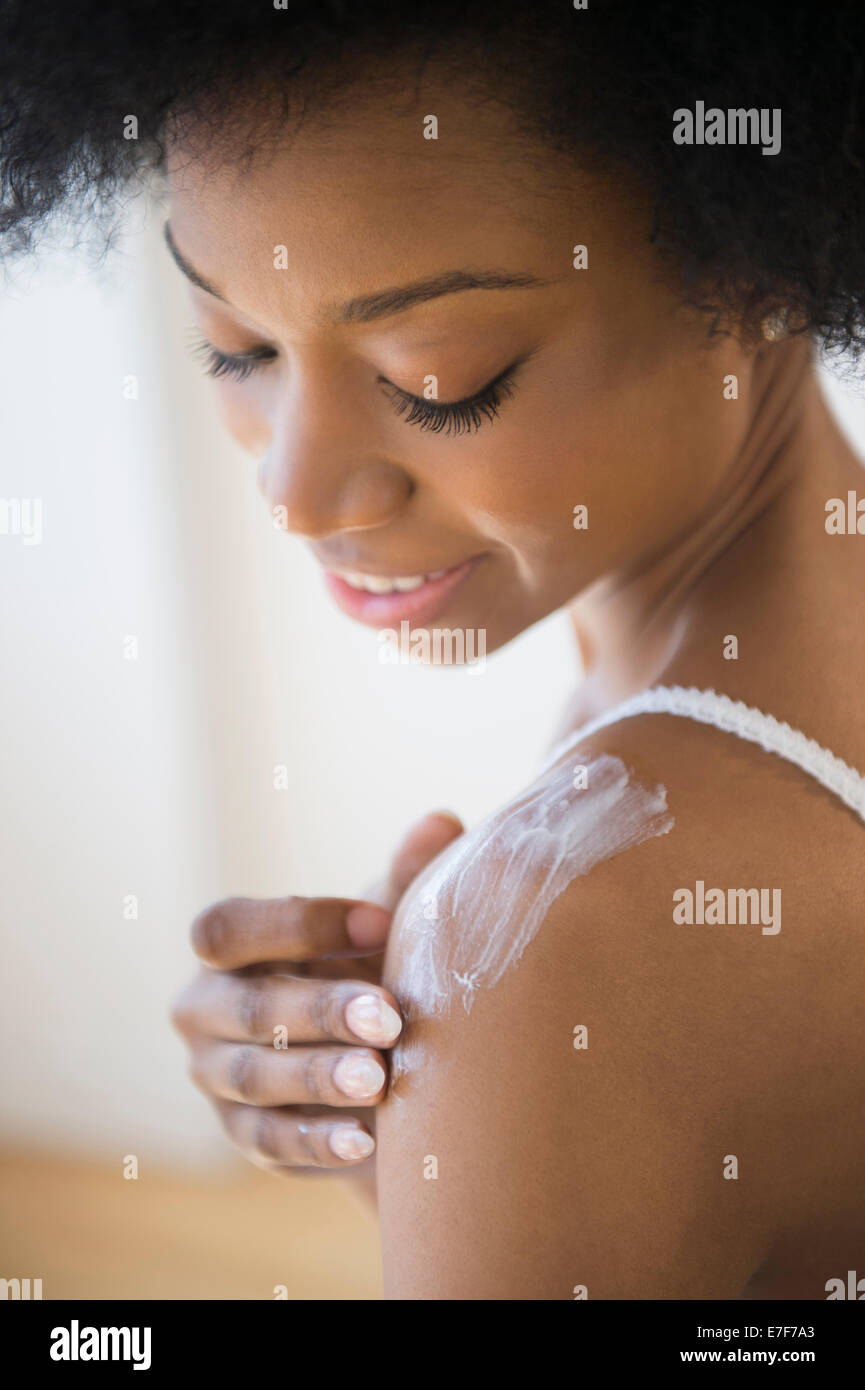 African American Woman applying moisturizer Banque D'Images