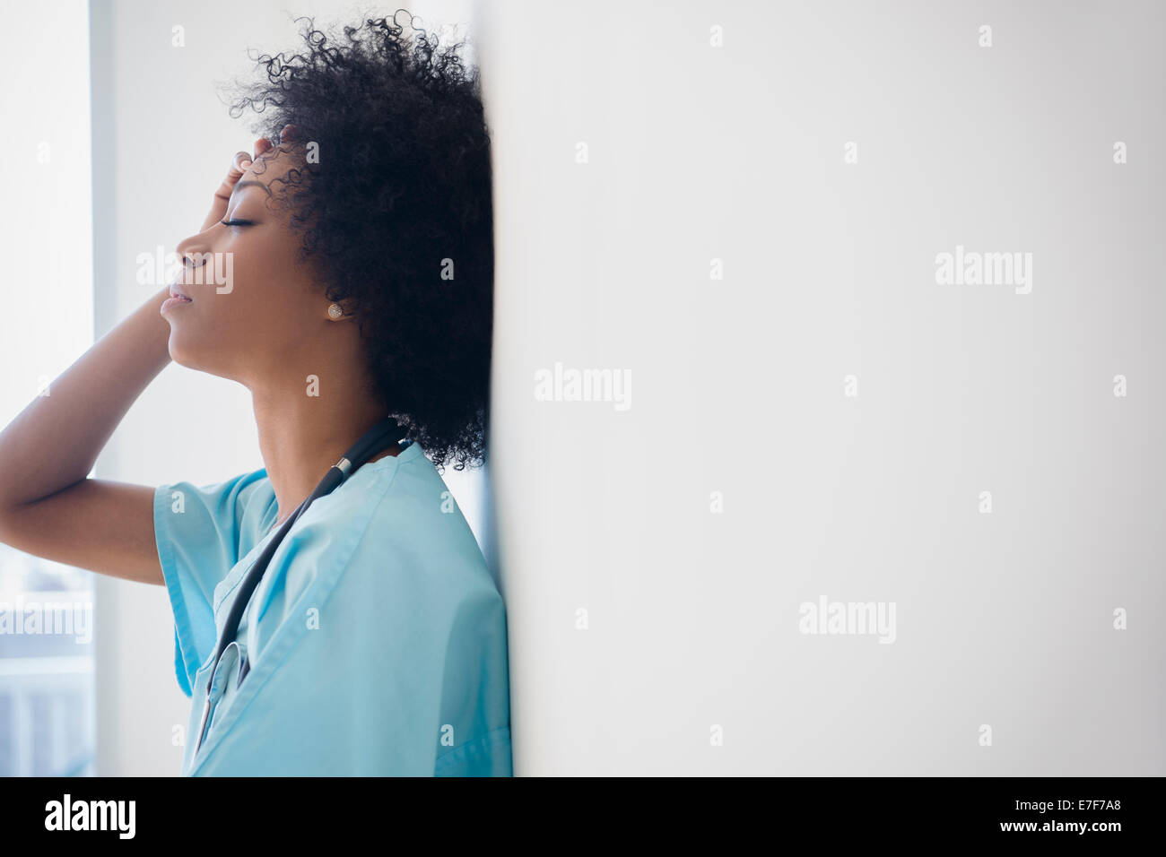 African American nurse leaning against wall Banque D'Images