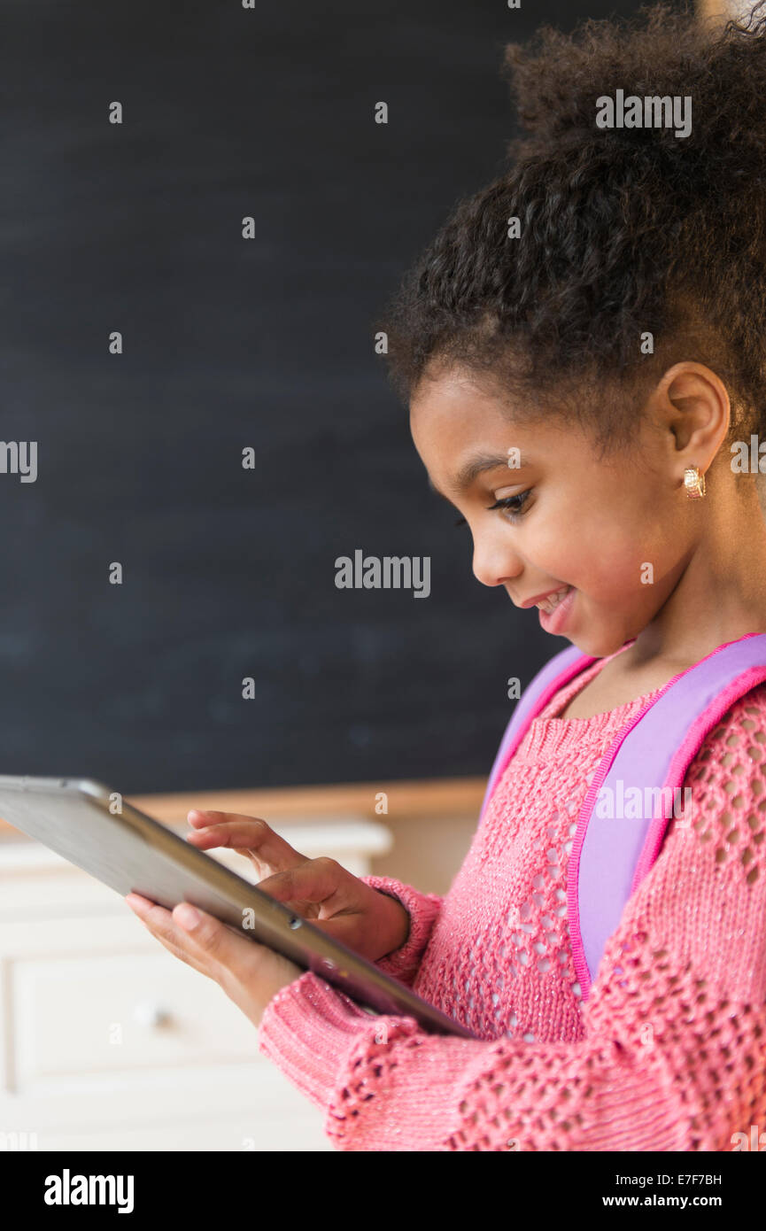 African American girl using tablet computer in classroom Banque D'Images
