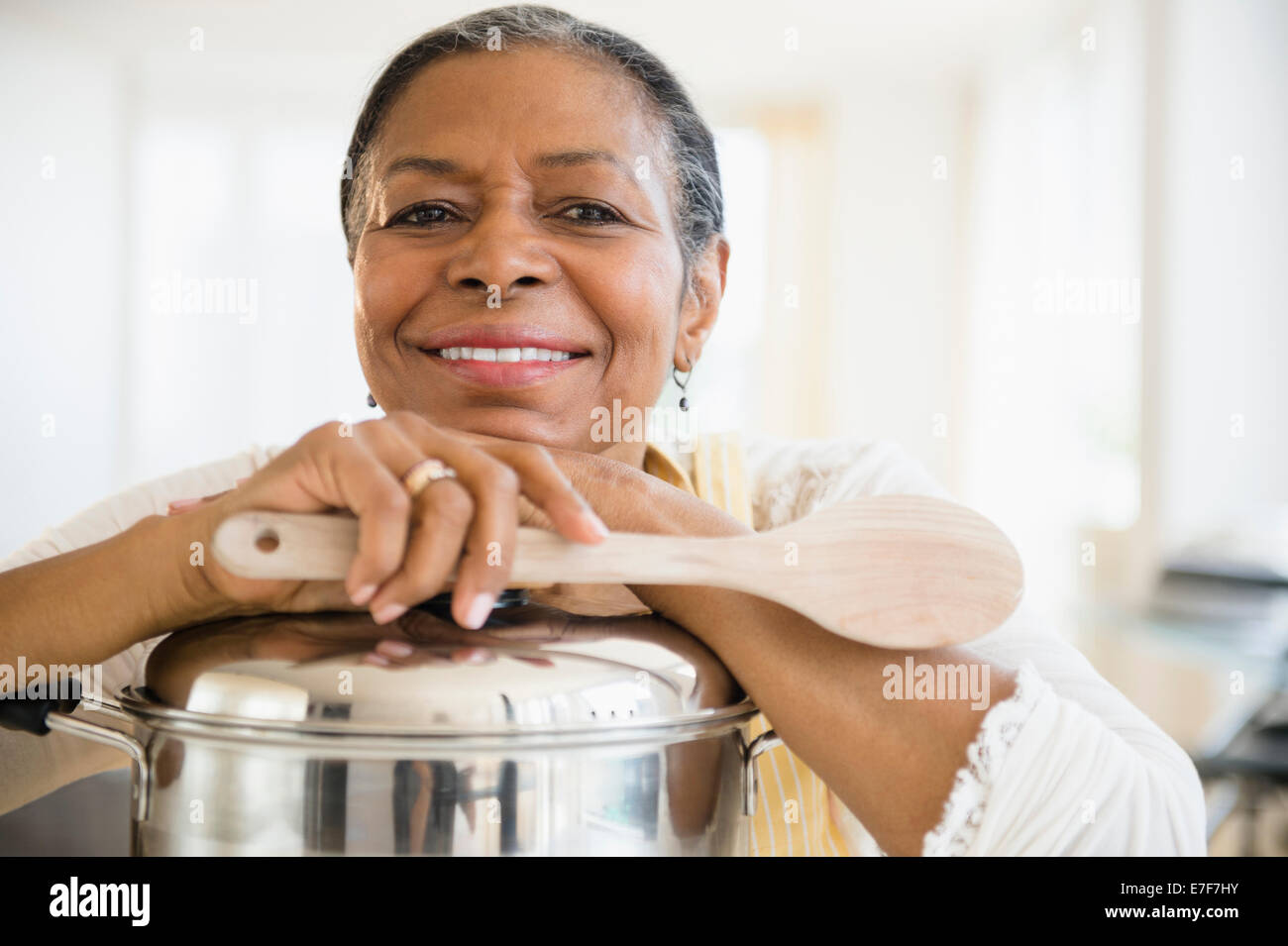 Mixed Race woman cooking in kitchen Banque D'Images