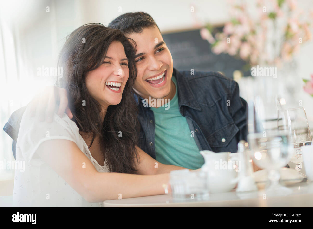 Hispanic couple laughing in cafe Banque D'Images