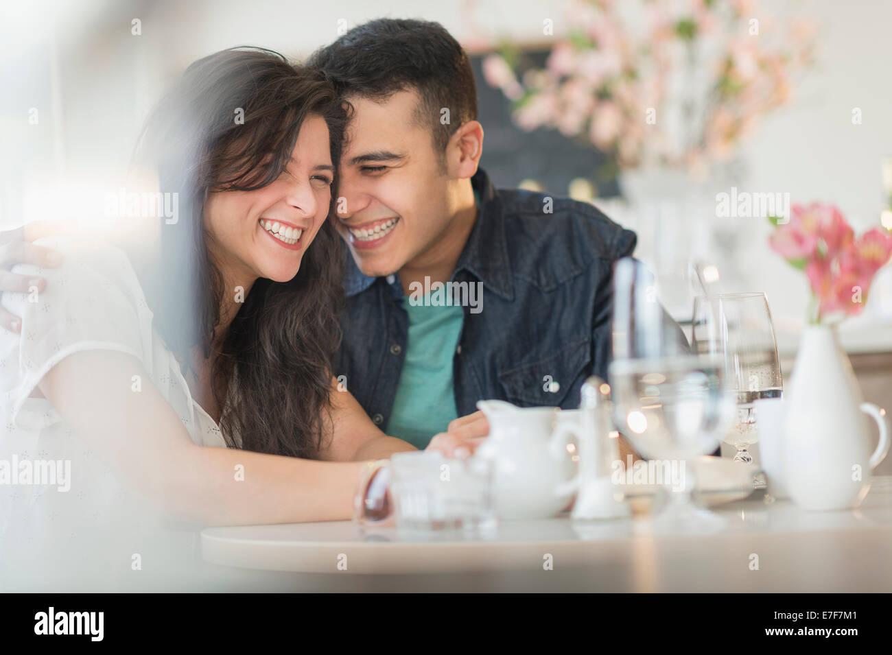 Hispanic couple laughing in cafe Banque D'Images