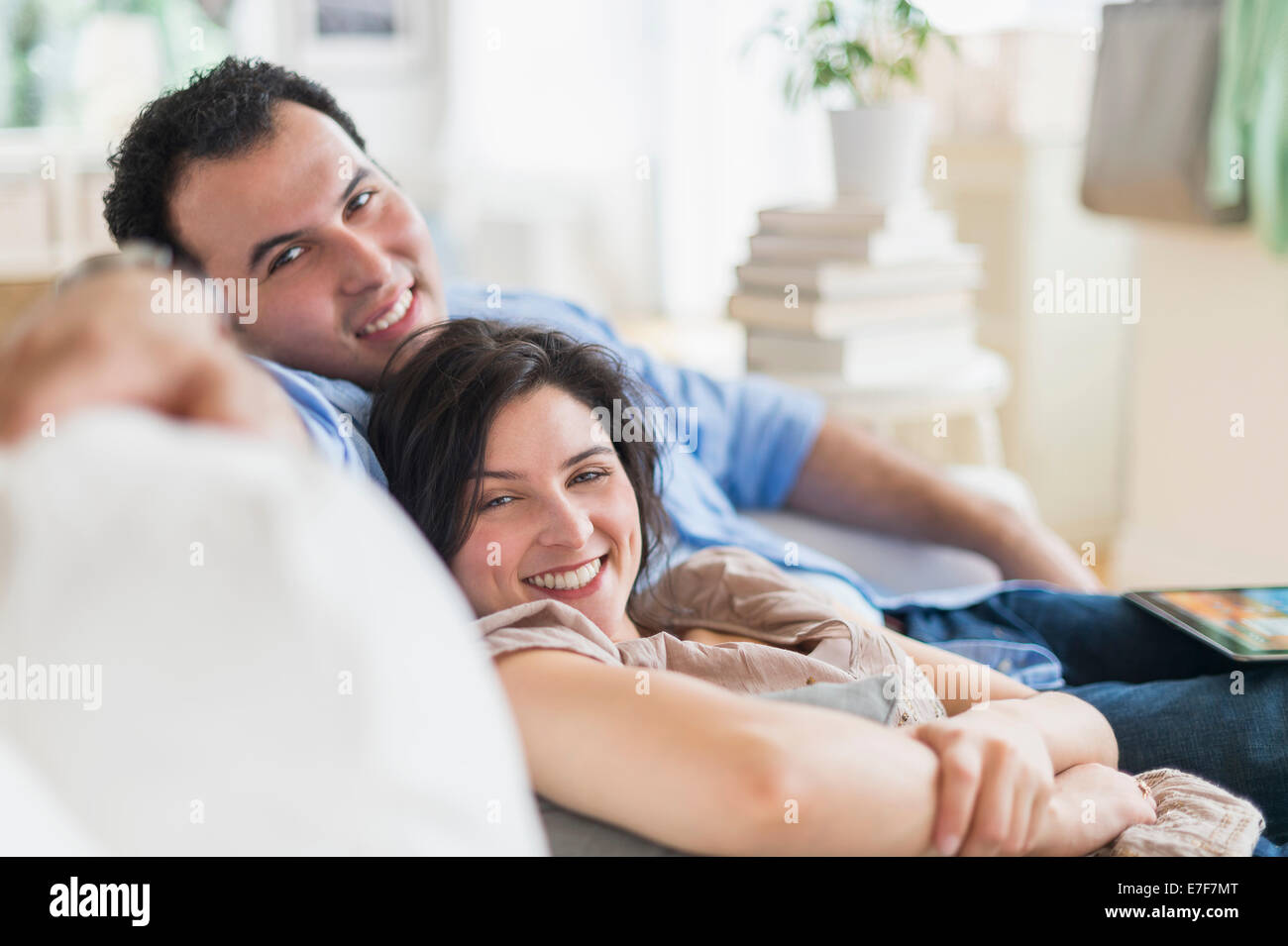 Hispanic couple relaxing together on sofa Banque D'Images